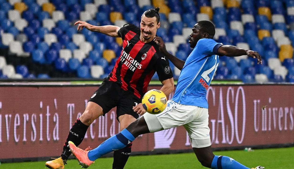 Pemain AC Milan Zlatan Ibrahimovic (kiri) mencoba melewati pemain Napoli Kalidou Koulibaly  pada pertandingan Serie A di Stadion San Paolo, Naples, Italia, Minggu (22/11/2020). Dua gol Ibrahimovic membawa AC Milan menaklukkan Napoli dengan skor 3-1. (ANDREAS SOLARO/AFP)