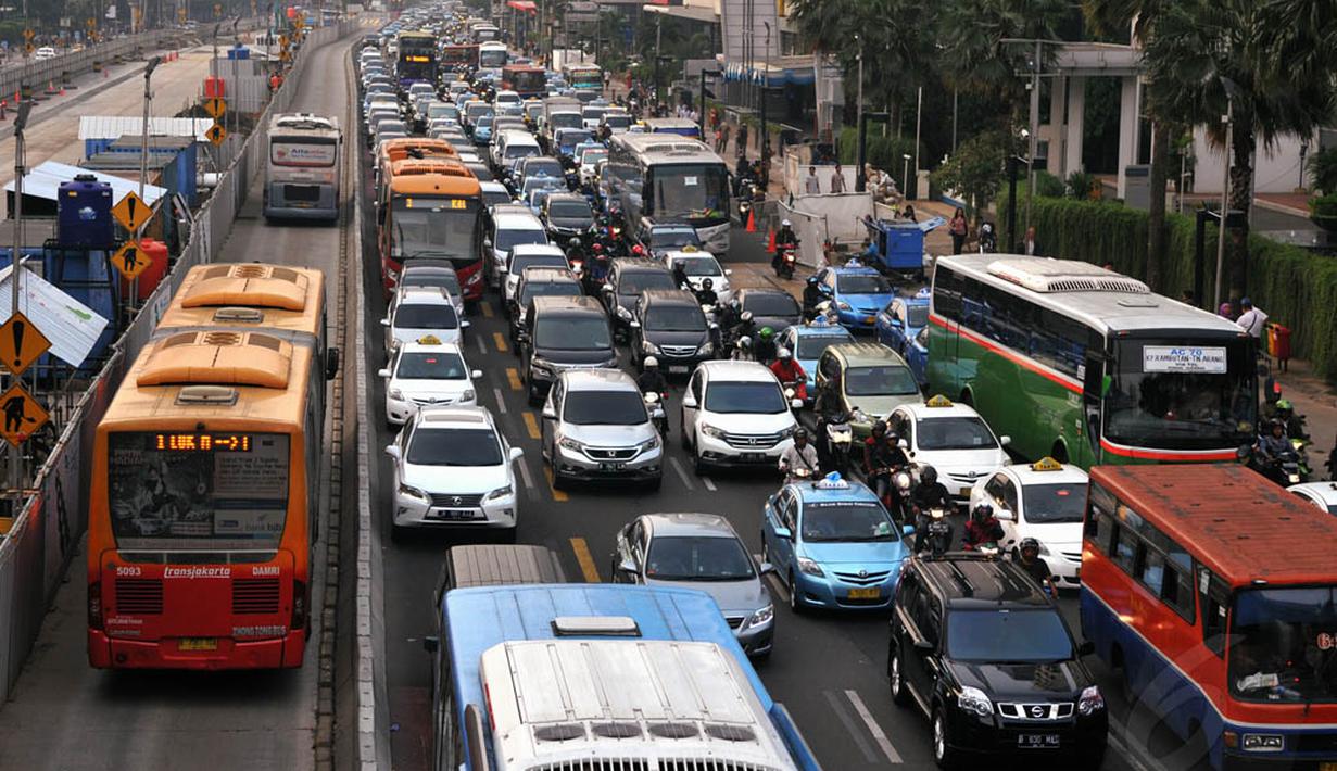 Beberapa pengguna jalan dan armada bus Transjakarta saat melintas di Jalan MH Thamrin, Jakarta, Rabu (4/6/14). (Liputan6.com/Johan Tallo)