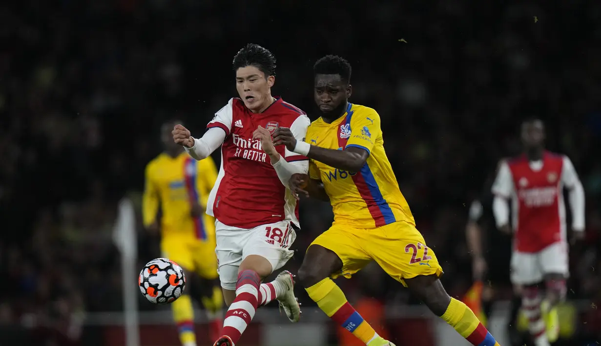 Bek Arsenal, Takehiro Tomiyasu berebut bola dengan pemain Crystal Palace, Odsonne Edouard  pada pertandingan lanjutan Liga Inggris di Stadion Emirates, London, Selasa (19/10/2021). Arsenal bermain imbang atas Crystal Palace 2-2. (AP Photo/Alastair Grant)
