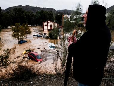 Seorang pria mengamati beberapa mobil yang tersapu air di kota Alora, Malaga, Spanyol, Selasa, 29 Oktober 2024. (AP Photo/Gregorio Marrero)