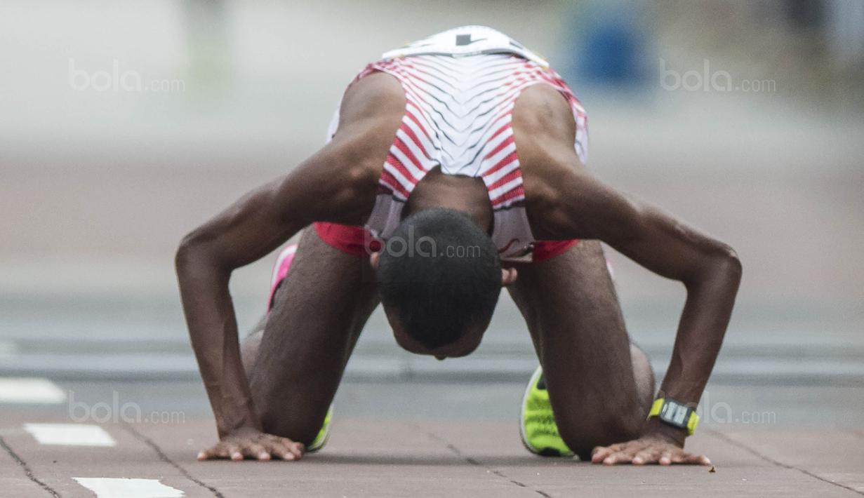 Pelari Indonesia, Agus Prayogo, sujud usai tampil pada nomor marathon SEA Games di Putrajaya, Kuala Lumpur, Sabtu (19/8/2017). Agus meraih medali perak dengan waktu dua jam 27 menit 16 detik. (Bola.com/Vitalis Yogi Trisna)