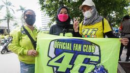 Tiga orang fans Valentino Rossi di depan Hotel Kempinski usai parade pembalap MotoGP, Moto2, Moto3, ATC, dan klub motor dari Istana Merdeka hingga Hotel Kempinski di Bundaran HI Jakarta Pusat, Rabu (16/03/2022). (Bola.com/Bagaskara Lazuardi)