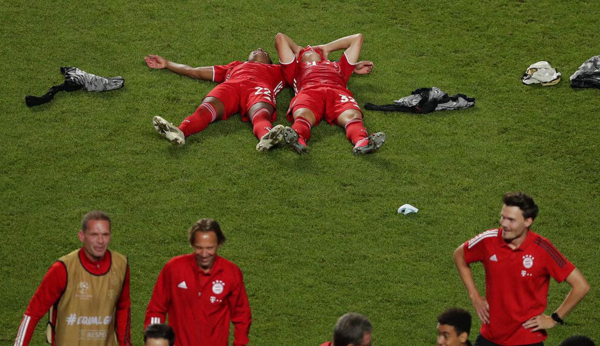 Pemain Bayern Munchen, Serge Gnabry dan Joshua Kimmich tidur di lapangan saat melakukan selebrasi usai menjuarai Liga Champions di Stadion The Luz, Portugal, Senin (24/8/2020). Bayern Munchen berhasil menjadi juara usai menaklukkan PSG 1-0. (Miguel A. Lopes/Pool via AP)