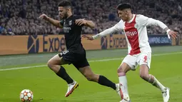 Penyerang Benfica, Goncalo Ramos (kiri) membawa bola dari kejaran pemain Ajax, Edson Alvarez pada pertandingan leg kedua babak 16 besar Liga Champions di Johan Cruyff ArenA di Amsterdam, Belanda, Rabu (16/3/2022). Benfica menang atas Ajax 1-0. (AP Photo/ Peter Dejong)