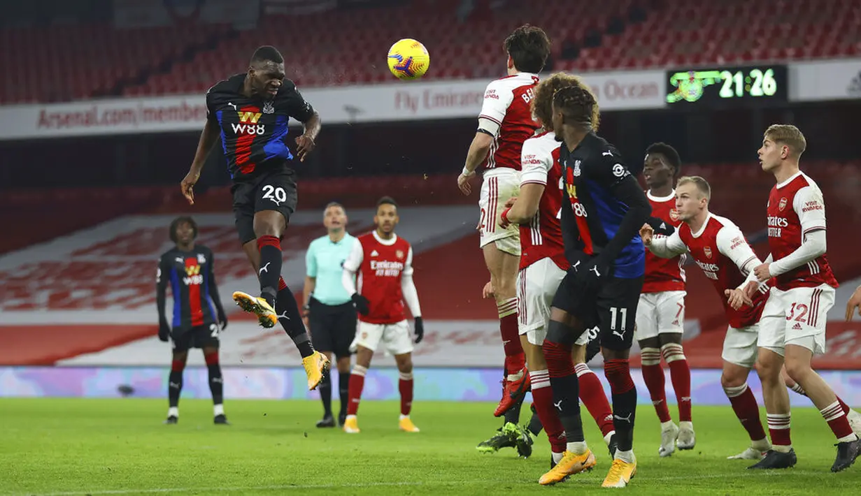 Pemain Crystal Palace Christian Benteke (kiri) menyundul bola ke Arsenal pada pertandingan Liga Inggris di Emirates Stadium, London, Inggris, Kamis (14/1/2021). Pertandingan berakhir imbang 0-0. (Julian Finney/Pool via AP)