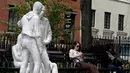 Dua perempuan duduk di dekat patung yang disebut 'Gay Liberation' di Christopher Park, Greenwich Village New York City, AS, (9/5). Patung ini dibuat untuk memperingati peristiwa pembebasan gay dan lesbian di Amerika Serikat. (REUTERS / Brendan McDermid)