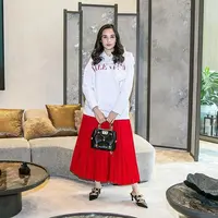 Ciptakan kesan elegan pada tampilan kasualmu dengan padu padan hoodie putih, rok plisket, pointed heels, dan mini bag seperti potret Chelsea Islan yang satu ini. (Instagram/chelseaislan).