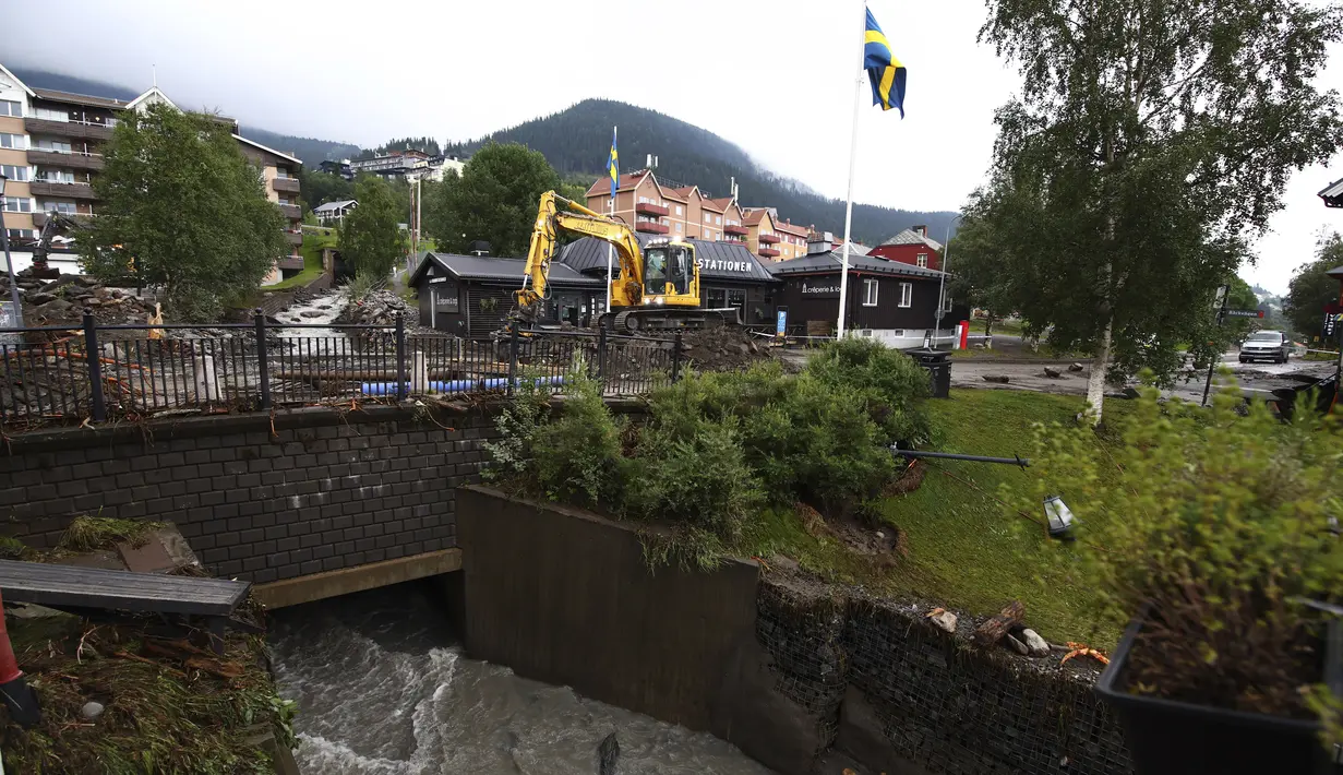 Di kota Are Swedia, sebuah resor ski, jalan dan jalan tergenang air. Sungai Susaback yang mengalir melalui Are, sekitar 533 kilometer (331 mil) dari Stockholm, melewati tepiannya dan membanjiri sebagian besar pusat kota. (Johan Nilsson/TT News Agency via AP)