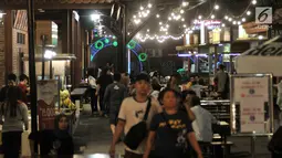 Orang-orang mengunjungi area Food Street di Pulau D reklamasi atau Pantai Maju, Jakarta, Selasa (29/1). Tidak hanya menyajikan makanan, pengunjung juga bisa menikmati alunan musik nan syahdu yang disajikan sepanjang malam. (Merdeka.com/Iqbal S. Nugroho)