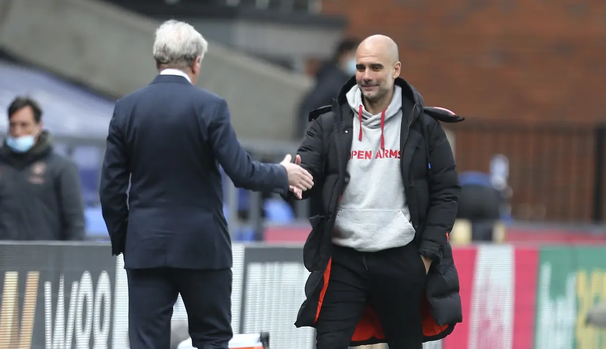 Manajer tim Crystal Palace, Roy Hodgson (kiri) menyalami manajer tim Manchester City, Pep Guardiola usai berakhirnya laga lanjutan Liga Inggris 2020/2021 pekan ke-34 di Selhurst Park, London, Sabtu (1/5/2021). Crystal Palace kalah 0-2 dari Manchester City. (AP/Catherine Ivill/Pool)