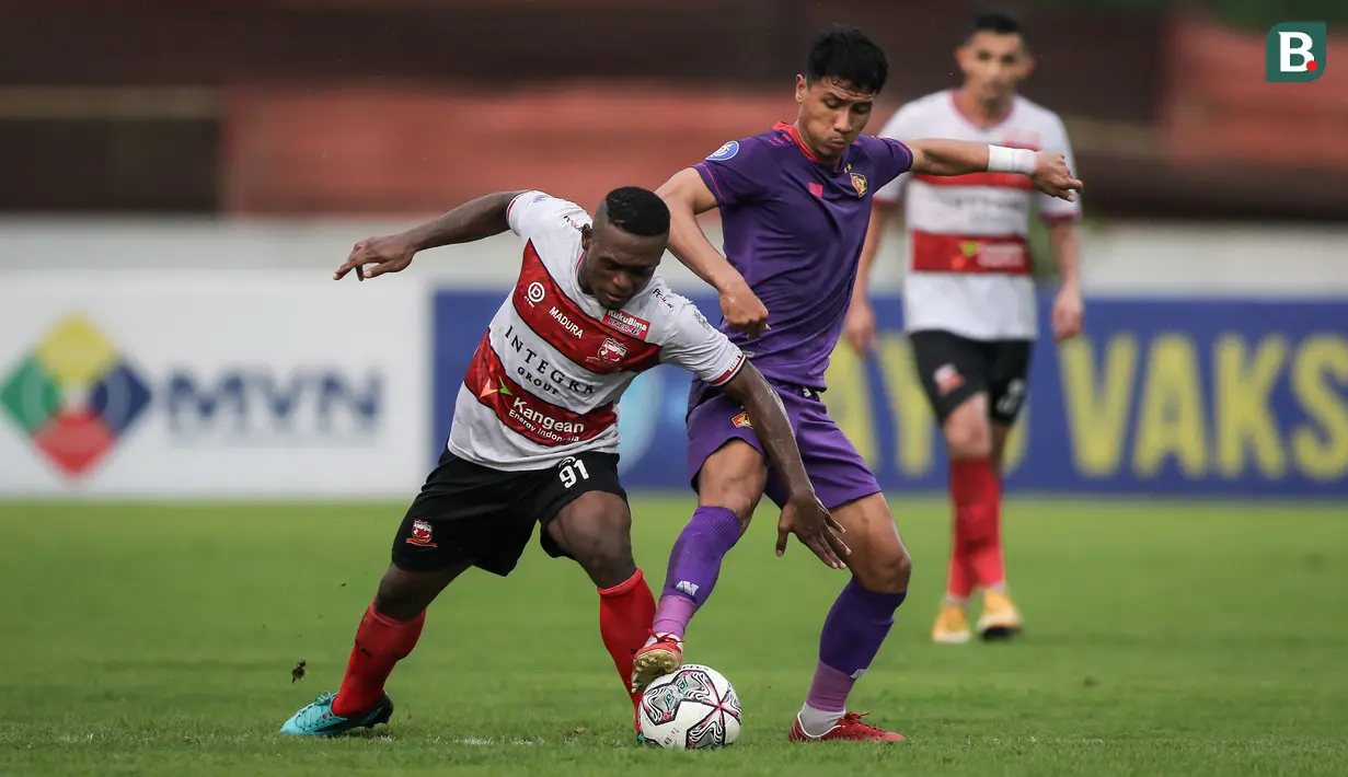 Pemain Madura United, David Laly (kiri) berebut bola dengan pemain Persik Kediri, Ady Eko Jayanto dalam laga pekan ke-13 BRI Liga 1 2021/2022 di Stadion Moch. Soebroto, Magelang, Rabu (24/11/2021). (Bola.com/Bagaskara Lazuardi)