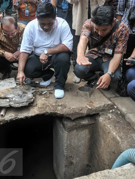 Plt Gubernur DKI Jakarta Sumarsono (baju putih) melihat gorong-gorong yang sedang dibersihkan petugas di Jalan Gatot Subroto, Jumat (10/3). Kawasan tersebut bagian dari lokasi ditemukan sampah kulit kabel di dalam gorong-gorong (Liputan6.com/Yoppy Renato)