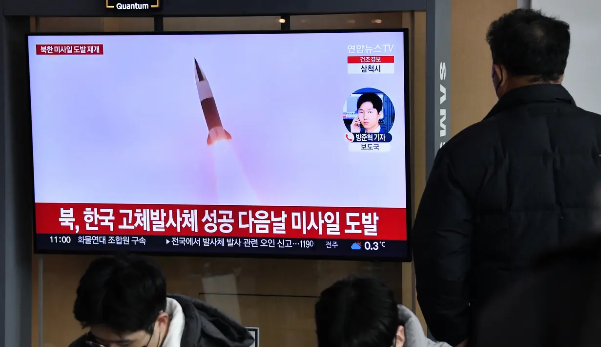 Seorang pria menonton layar televisi yang menayangkan siaran berita dengan rekaman file uji coba rudal Korea Utara, di sebuah stasiun kereta api di Seoul, Sabtu (31/12/20220). Ketiga rudal balistik jarak dekat itu dilaporkan jatuh ke perairan sebelah timur Semenanjung Korea. (Jung Yeon-je / AFP)