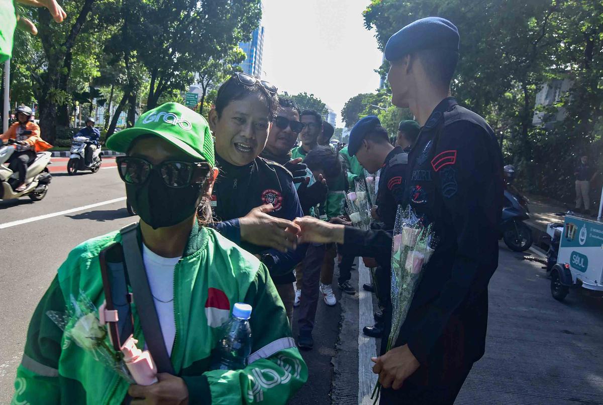 FOTO: Aksi Damai Ojol Tebar Mawar untuk Perdamaian