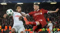 Pemain Spartak Moscow, Luiz Adriano berebut bola dengan pemain Liverpool, Alberto Moreno pada matchday terakhir Grup E Liga Champions di Stadion Anfield, Kamis (7/12). Liverpool menang 7-0 dan lolos ke babak 16 besar. (AP/Rui Vieira)