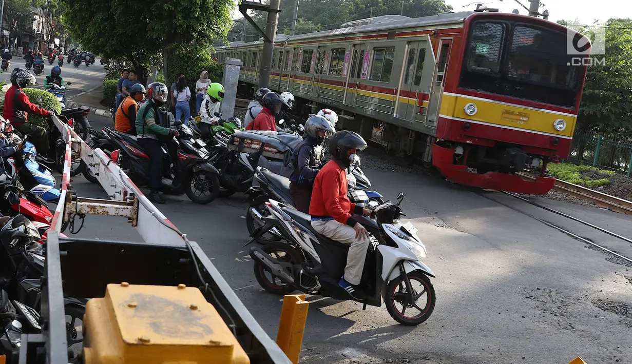 Kereta api melintas di kawasan Lenteng Agung, Jakarta, Kamis (14/3). Untuk mengurai kemacetan, Pemprov DKI Jakarta akan membangun jalan layang (fly over) berbentuk tapal kuda di perlintasan tersebut. (Liputan6.com/Immanuel Antonius)