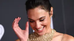 Aktris Gal Gadot tersenyum saat tiba menghadiri pemutaran perdana film produksi Warner Bros 'Justice League' di Teater Dolby di Hollywood, California, AS (13/11). Gal Gadot tampil cantik dengan gaun emas berkilauan. (AFP Photo/Robyn Beck)