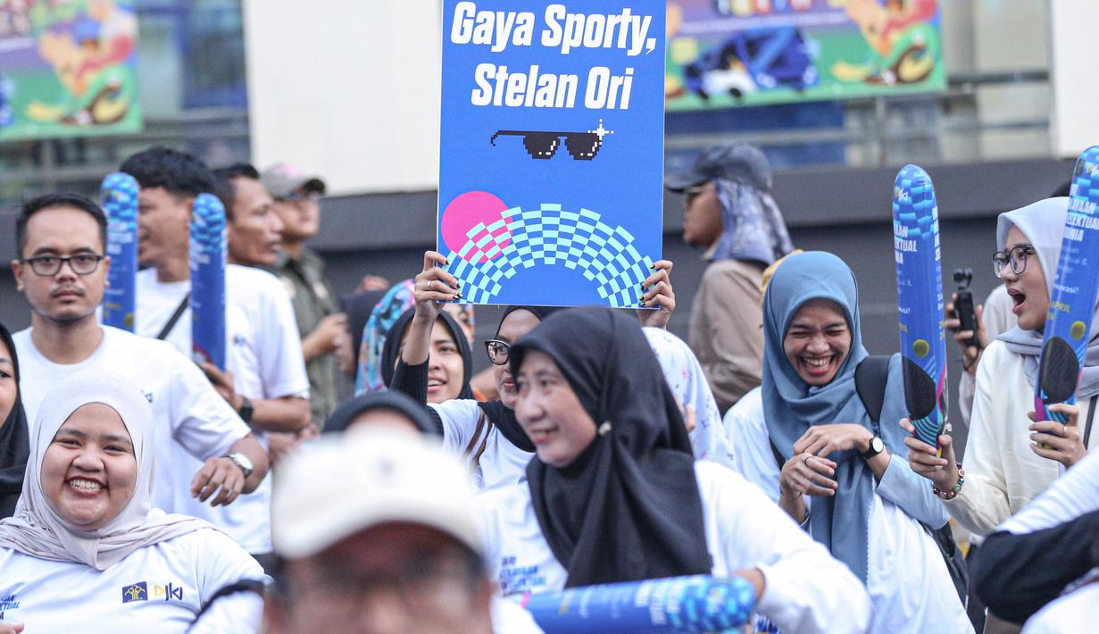 Salah satu peserta fun walk membentangkan tulisan sebagai bentuk kampanye dalam acara peringatan Hari Kekayaan Intelektual Sedunia 2026 yang berlangsung di Sarinah, Jakarta Pusat pada Minggu (26/4/2026). (Bola.com/Abdul Aziz)