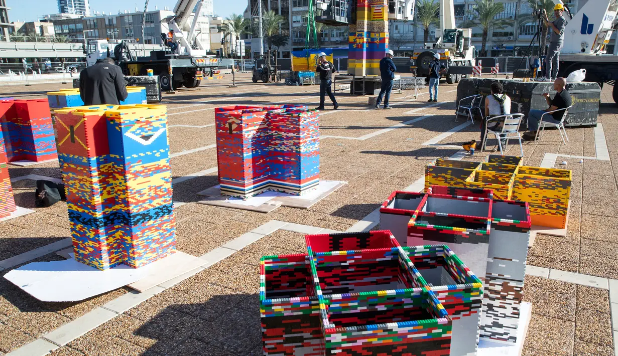 Kepingan LEGO yang berbentuk menyerupai batu bata siap disusun menjadi menara di Lapangan Rabin di Tel Aviv, Israel, Rabu (27/12). Menara dengan setengah juta batu bata berwarna-warni dinobatkan sebagai "Menara Omer". (AFP Photo/Jack Guez)