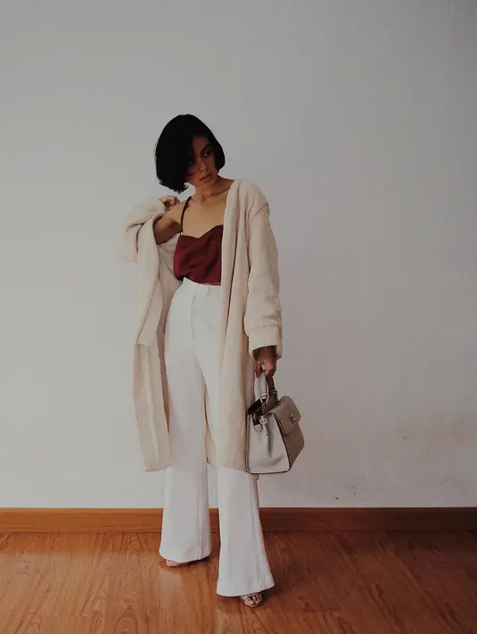 Mengenakan celana kulot berwarna putih dan atasan tank top merah dan outer broken white membuat Eva terlihat seksi banget. Apalagi dengan rambut bobnya yang pendek, jadi makin keren pastinya. (Instagram/evacelia)