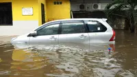 Sebuah mobil terjebak banjir di kawasan Grogol, Jakarta Barat, Rabu (11/2/2015). Hingga kini sejumlah kawasan di Jakarta masih tergenang banjir akibat dari hujan dengan intensitas tinggi yang mengguyur pada Minggu (8/2). (Liputan6.com/Faisal R Syam)