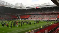 Suporter Manchester United atau MU merangsek masuk hingga ke lapangan Old Trafford dalam aksi unjuk rasa, Minggu (2/5/2021) (AFP/Oli Scarff)