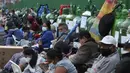 Orang-orang duduk di dekat tabung oksigen kosong mereka saat menunggu toko isi ulang dibuka di lingkungan San Juan de Lurigancho di Lima, Peru, Senin (22/2/2021). Menurut pemerintah, permintaan oksigen medis tumbuh 200 persen di Peru di tengah gelombang kedua Covid-19. (AP Photo/Martin Mejia)