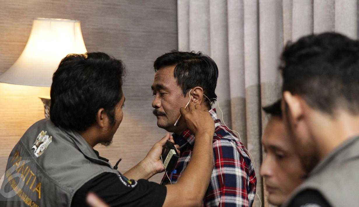 Panitia memasang clip on ke calon Wakil Gubernur DKI Jakarta no 2, Djarot Saiful Hidayat sebelum debat terakhir Pilgub DKI Jakarta dimulai di Hotel Bidakara, Jakarta, Rabu (12/4). (Liputan6.com/Faizal Fanani)