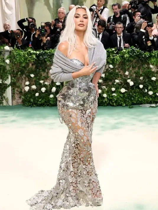 Kim Kardashian berani telanjang mengenakan gaun Maison Margiela Couture karya John Galliano yang menampilkan korset berwarna perak dan rok berkabel tangan berbahan elemen logam. [@metgalaofficial_]