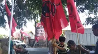Sejumlah petugas Satpol PP tengah mencopot baliho dan bendera Partai politik. (Merdeka.com)
