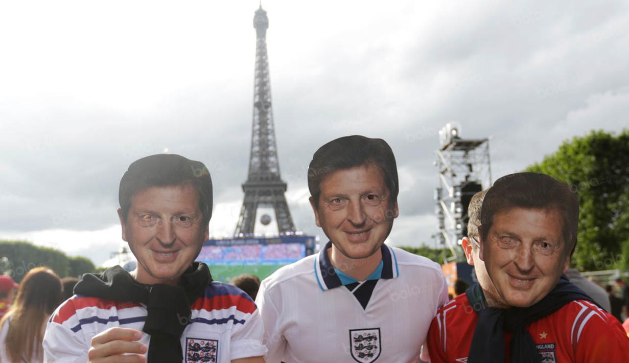 Tiga orang fans Inggris memakai topeng berbentuk wajah pelatih The Three Lions, Roy Hodgson, yang kini sudah mengundurkan diri dari jabatannya. (Bola.com/Vitalis Yogi Trisna)