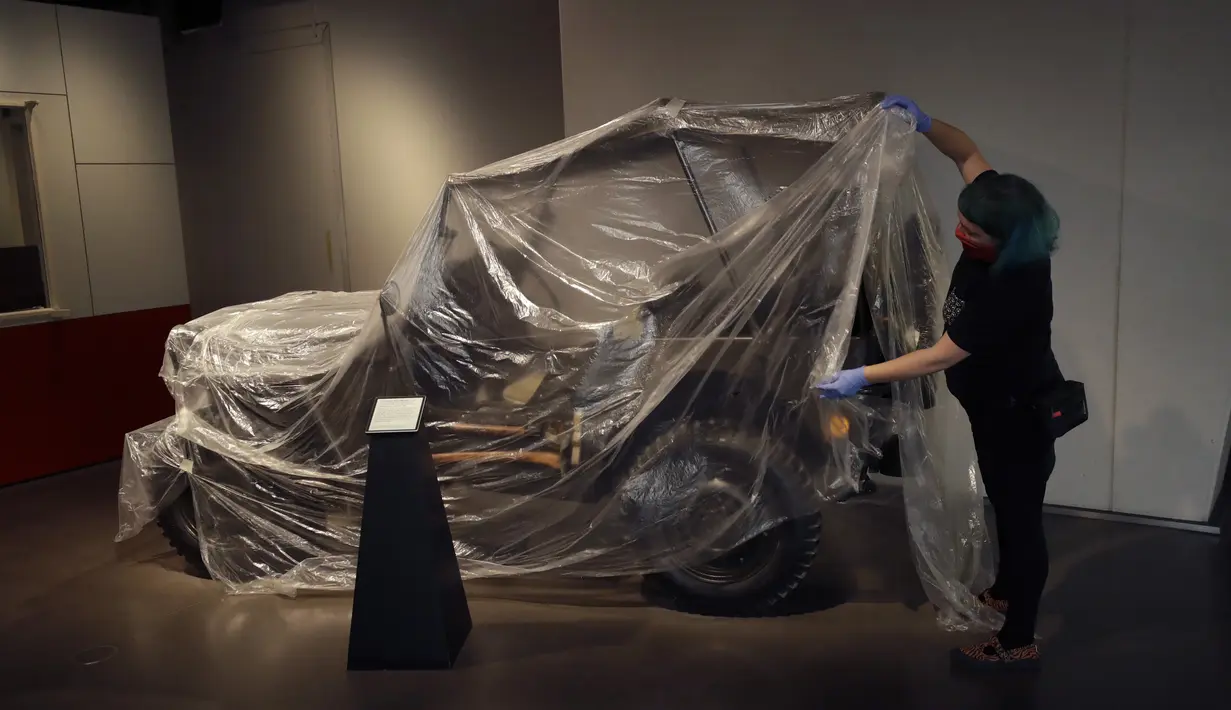 Teknisi membuka penutup Jeep Willys MB Amerika dari Perang Dunia II yang diberikan kepada Palang Merah Inggris di Imperial War Museum, London, Inggris, Rabu (29/7/2020). Museum ini akan kembali dibuka pada 1 Agustus 2020 setelah pemerintah Inggris terus melonggarkan lockdown. (AP Photo/Matt Dunham)