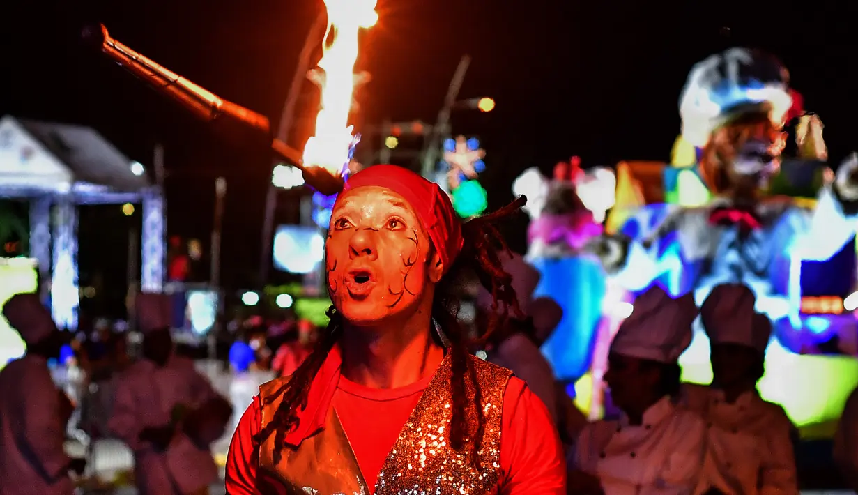 Seorang pria beraksi memainkan tongkat api selama parade Natal di Panama City (16/12). Warga Panama tengah mempersiapkan diri menyambut datangnya Natal 2018 yang jatuh pada tanggal 25 Desember. (AFP Photo/Luis Acosta)