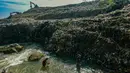 Warga memanfaatkan aliran Kali Pesanggrahan yang menyempit untuk mendulang benda-benda logam di kawasan Pasir Putih, Depok, Jawa Barat, Senin (27/4/2026), setelah longsoran sampah dari Tempat Pembuangan Akhir (TPA) Cipayung menutup sebagian badan sungai. (merdeka.com/Arie Basuki)