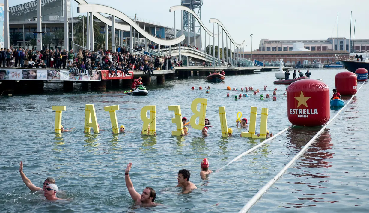 Para peserta bersaing selama kompetisi renang Copa Nadal edisi ke-109 di Port Vell Barcelona, Selasa (25/12). Lomba renang tradisonal ini berlangsung pada hari natal sejak 1908 di pelabuhan tua Barcelona. (Josep LAGO / AFP)