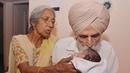  Daljinder Kaur (kiri) bersama sang suami Mohinder Singh Gill saat mengasuh anak mereka di Amritsar, India, (11/5).Setelah menikah selama 46 tahun, pasangan lansia ini akhirnya berhasil memiliki buah hati melalui program bayi tabung.( NARINDER NANU / AFP)