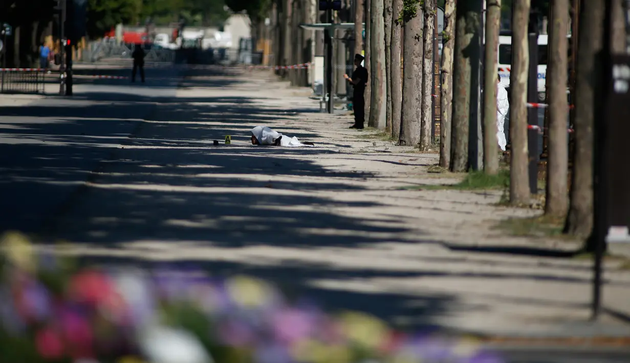 Jasad seorang pria tergeletak usai serangan terhadap van polisi di Champs Elysees, Paris, Senin (19/6). Dua pejabat polisi mengatakan pria 31 tahun itu berasal dari pinggiran kota Paris yang sudah ditandai karena aktivitasnya (AP Photo/Matthieu Alexandre)