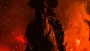 Seorang pria menunggang kuda melintasi kobaran api dalam tradisi tahunan Luminarias memperingati Hari Santo Anthony (santo pelindung hewan) di San Bartolome de Pinares, Spanyol, 16 Januari 2023. Tradisi yang sudah berlangsung selama 500 tahun ini dilakukan sebagai upaya 'pemurnian' hewan dengan cara melintasi kobaran api. (AP Photo/Manu Fernandez)