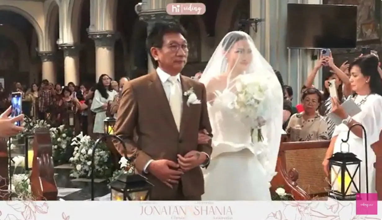Shanju tampil cantik dengan gaun putih dengan vail didampingi oleh sang ayah. Momen pernikahan Jojo dan Shanju terkuak dari kanal Youtube Viding. [Youtube/Viding]
