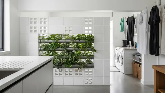 Inspirasi Area Jemuran Belakang Dapur dengan Roster Beton dan Tanaman Vertikal Pipa (Image by Gemini AI)