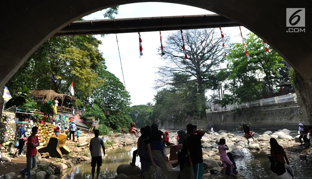 Warga bermain di kolong jembatan Sempur, Bogor (16/9). Musim kemarau yang menyebabkan debit Sungai Ciliwung menyusut drastis dimanfaatkan warga Bogor dan sekitarnya untuk berwisata murah dan gratis di aliran sungai. (Merdeka.com/Arie Basuki)