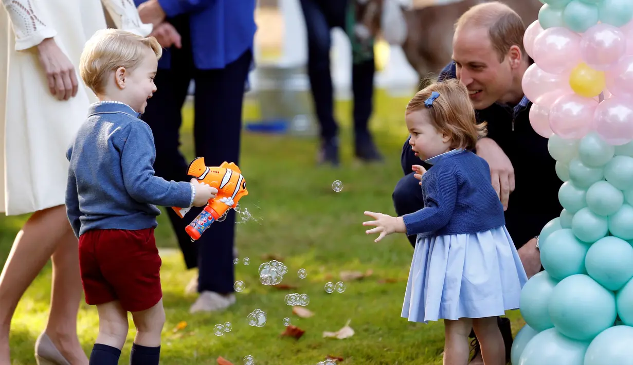 Pangeran George dan Putri Charlotte terlihat bergembira saat bermain pistol gelembung sabun dalam sebuah pesta untuk anak-anak di Government House di Victoria, British Columbia, Kanada, (29/9). (REUTERS/Chris Wattie)