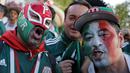 Suporter Meksiko menggunakan topeng saat merayakan kemenangan timnya atas Jerman pada laga grup F Piala Dunia 2018 di Luzhniki Stadium, Moskow, (17/6/2018). Meksiko menang 1-0. (AP/Alexander Zemlianichenko)