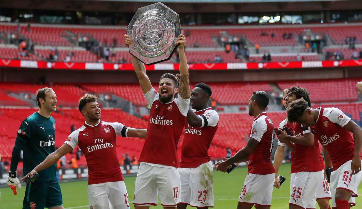 Pemain Arsenal Olivier Giroud mengangkat trofi usai menjuarai FA Community Shield di Stadion Wembley di London, Inggris (6/8). Arsenal berhasil menjadi juara usai mengalah Chelsea lewat adu pinalti 3-1. (AP Photo/Frank Augstein)