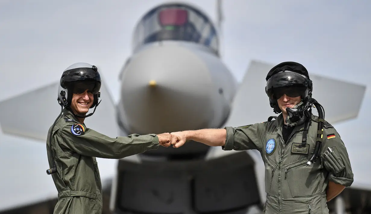 Pilot Israel (kiri) dan pilot Jerman berpose di depan Eurofighter, Noervenich, Jerman, Kamis (20/8/2020). Pilot Israel dan Jerman akan terbang bersama selama dua minggu ke depan selama latihan Angkatan Udara gabungan pertama di Jerman. (AP Photo/Martin Meissner)