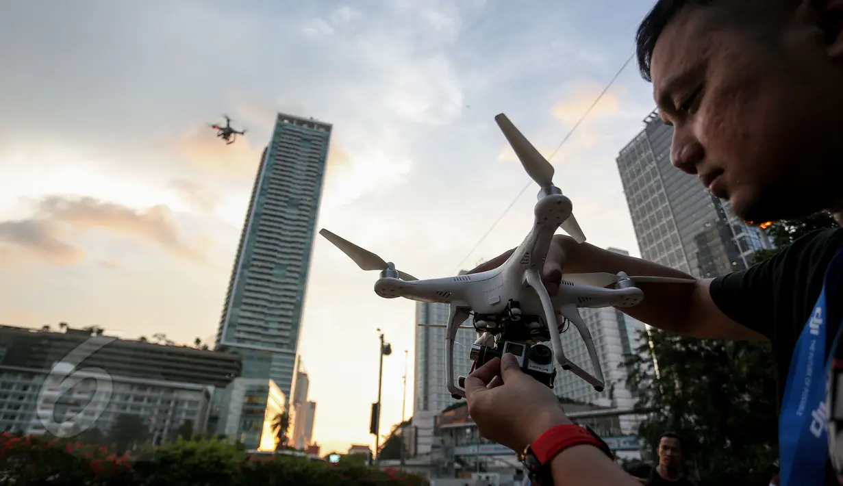 Seorang pilot drone terlihat memasangkan kamera ke drone di Bundaran HI, Jakarta, Kamis(28/5/2015). (Liputan6.com/Faizal Fanani)