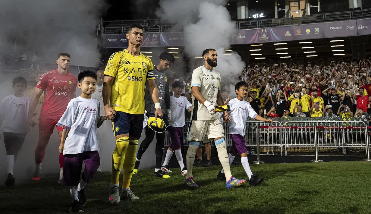 Cristiano Ronaldo memimpin rombongan pemain Al-Nassr saat memasuki lapangan pertandingan dalam laga semfinal Saudi Super Cup 2025 melawan Al-Ittihad di Hong Kong Stadium, Hong Kong, Selasa (19/08/2025) waktu setempat. (AP Photo/Chan Long Hei)