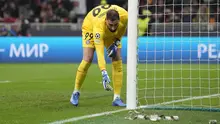 Penjaga gawang PSG, Gianluigi Donnarumma, menyingkirkan uang palsu bergambar dirinya yang dilempar pendukung AC Milan dalam laga matchday 4 Liga Champions 2023/2024 yang berlangsung di San Siro, Milan, Rabu (8/11/2023) dini hari WIB. (AP Photo/Antonio Calanni)