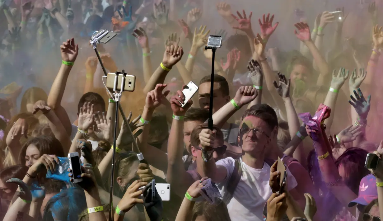 Sejumlah peserta berselfie saat mengikuti festival Holi di Riga, Latvia, (9/7). Orang merayakan Holi dengan saling melemparkan bubuk berwarna-warni atau saling menyiramkan air berwarna-warni. (REUTERS/Ints Kalnins)