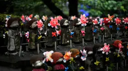 Patung-patung Jizo terlihat di Kuil Zojoji, Tokyo pada 22 Juni 2020. Jizo adalah pelindung dari anak-anak yang belum sempat lahir atau meninggal dalam kandungan dan saat masih bayi. (Photo by Philip FONG / AFP)